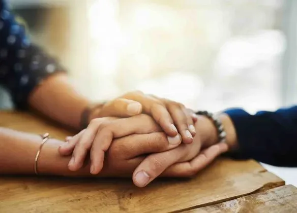 Soutien psychologique et réconfort par un serrement de mains lors d'un deuil.