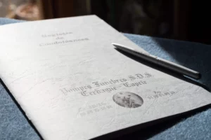 Registre de condoléances en papier des pompes funèbres pose sur une table.