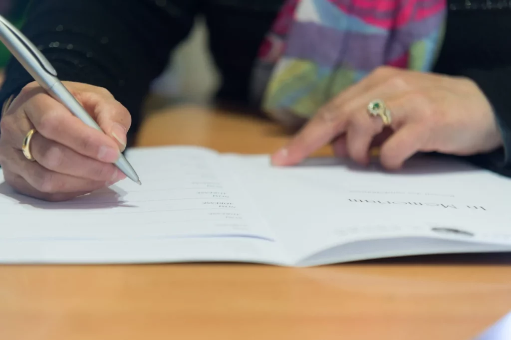 Registre de condoléances en papier des pompes funèbres pose sur une table.