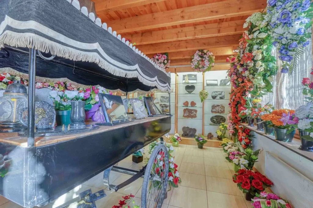 Ancien corbillard hippomobile exposé dans un magasin de pompes funèbres.